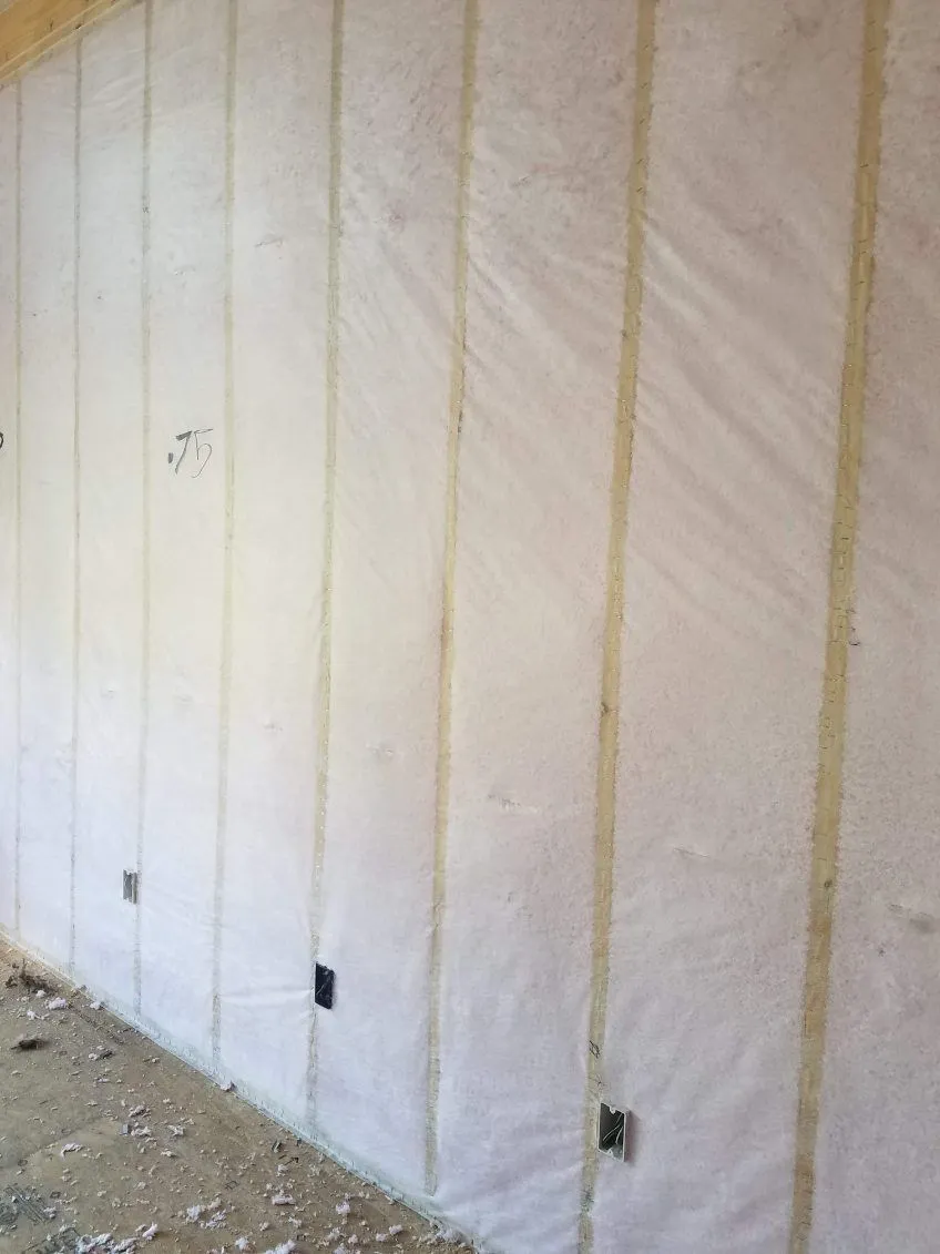 Netted blown-in wall insulation in a framed room during installation