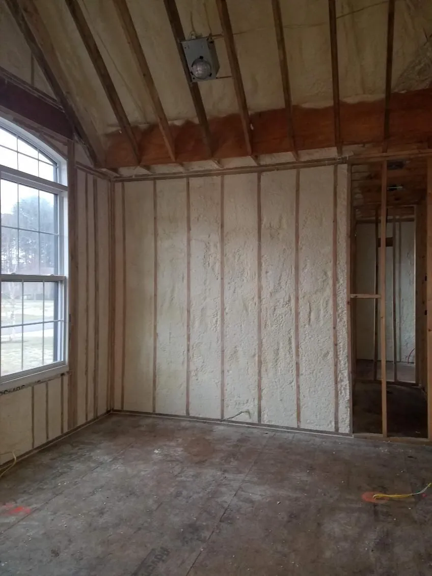 Spray foam insulated walls in a framed room with an arched window