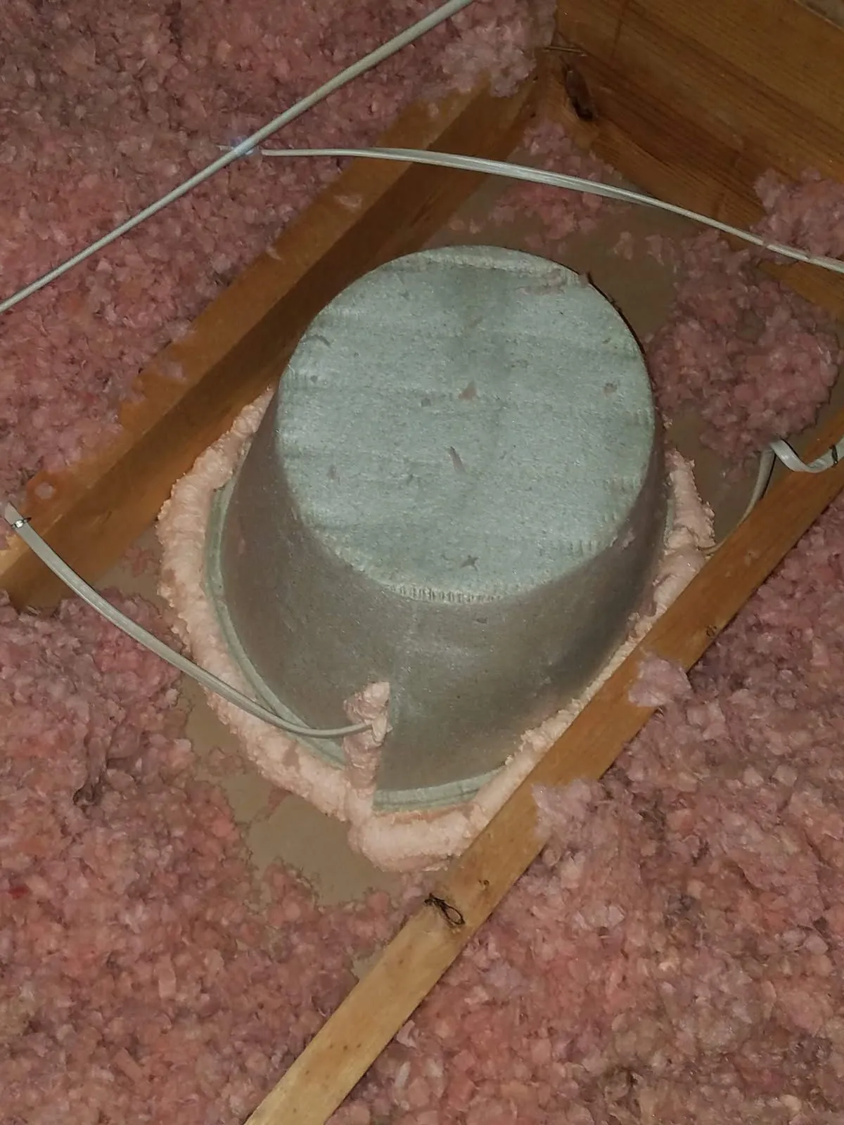 Attic penetration air-sealed with foam and surrounded by blown-in fiberglass