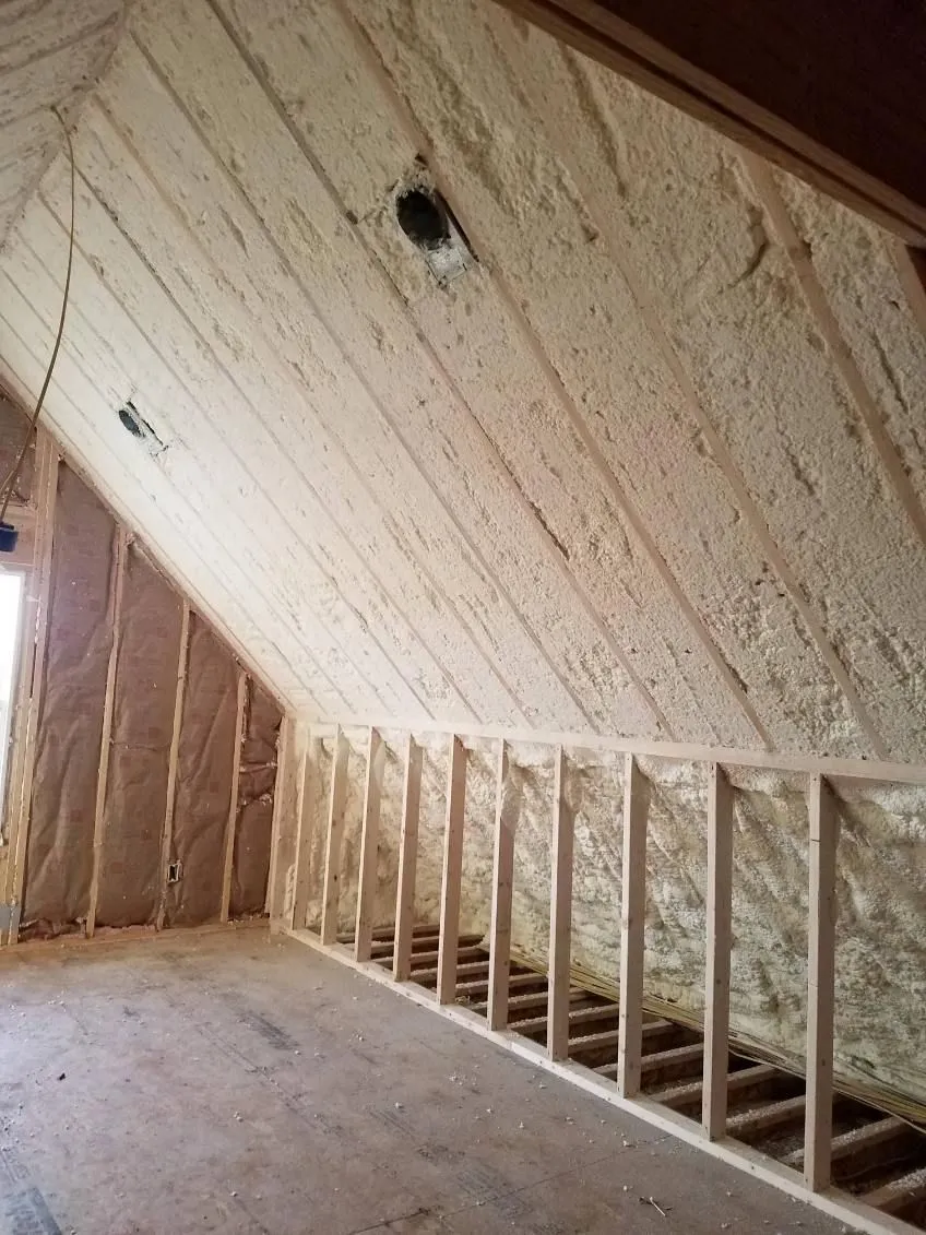 Spray foam insulation along an attic roofline above a knee wall