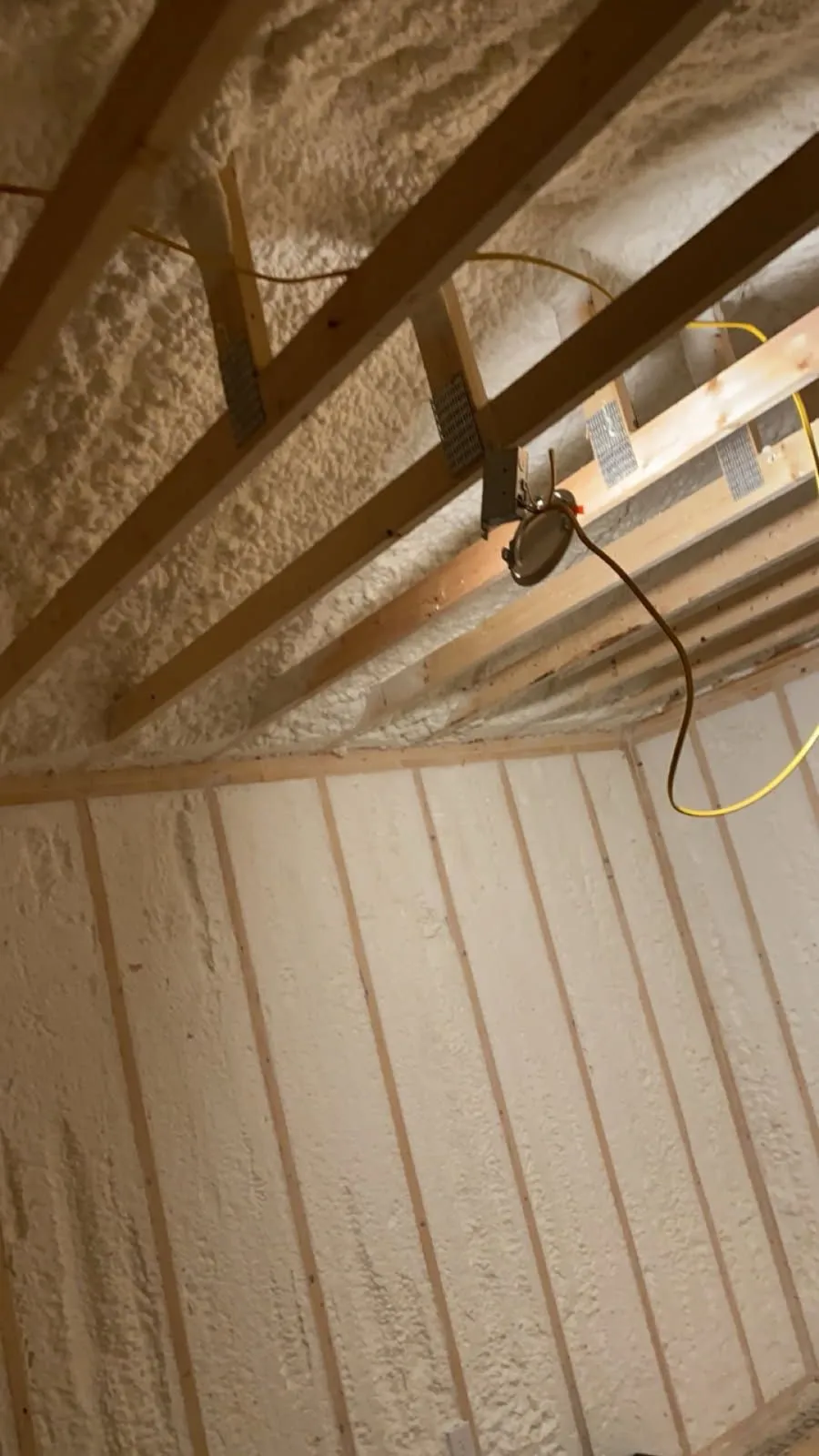 Spray foam insulation applied to the underside of a roof deck between rafters