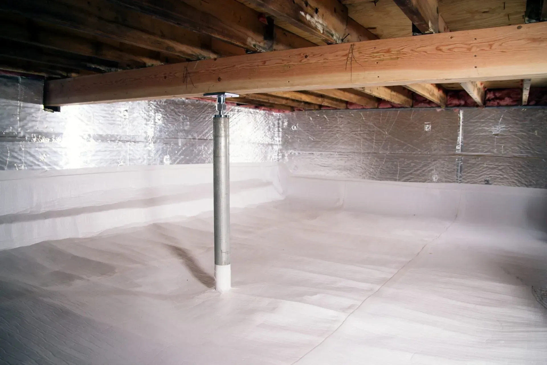 Finished crawl space encapsulation with a white liner over the ground and foil-faced wall insulation