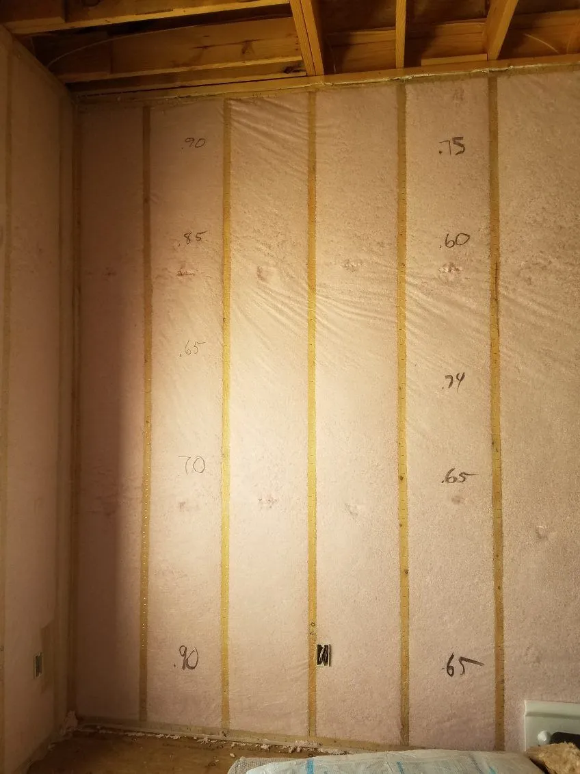 Netted blown-in wall insulation with the installed depth noted on each cavity
