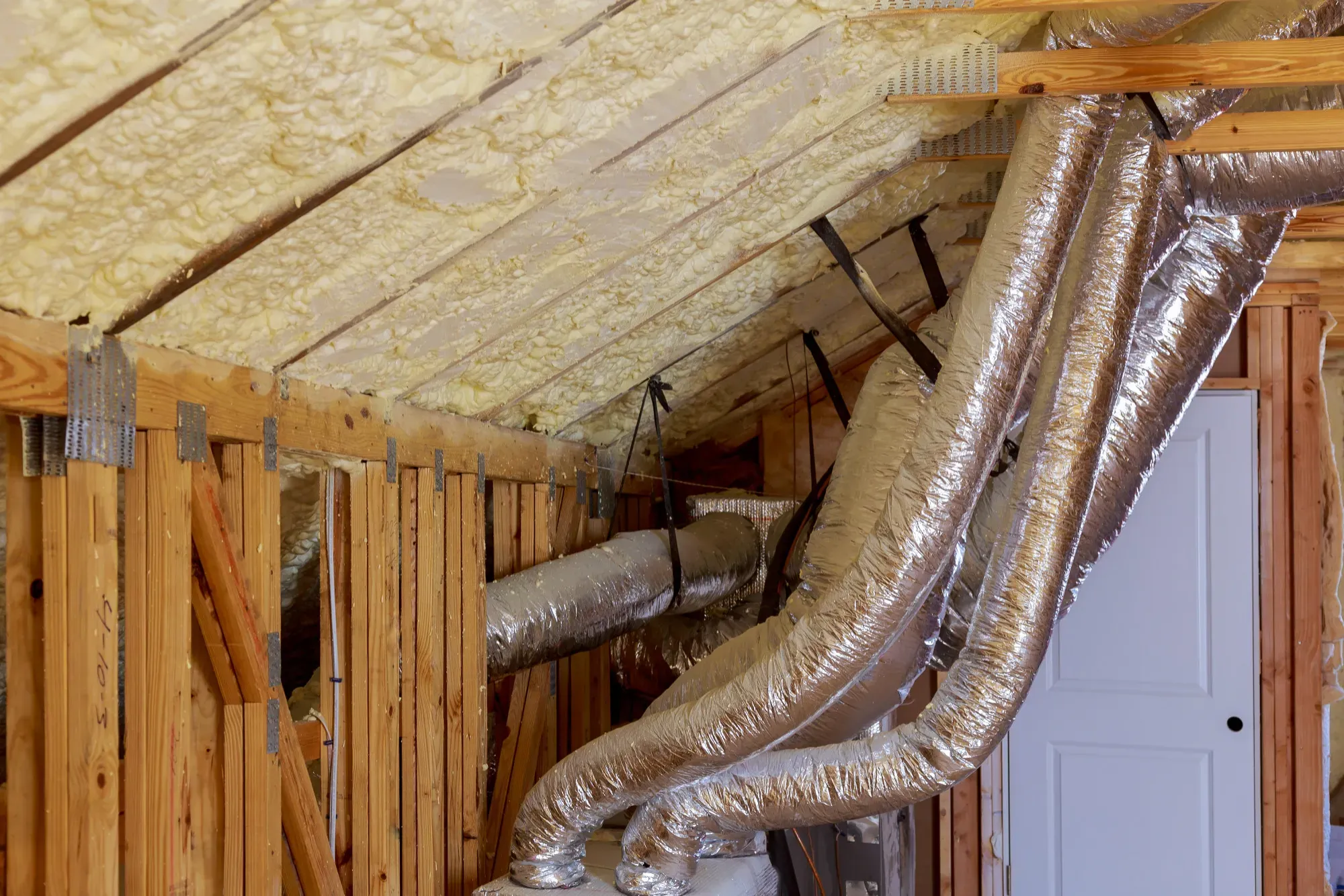 Attic with spray foam on the underside of the roof deck and insulated flex ducts run to the air handler