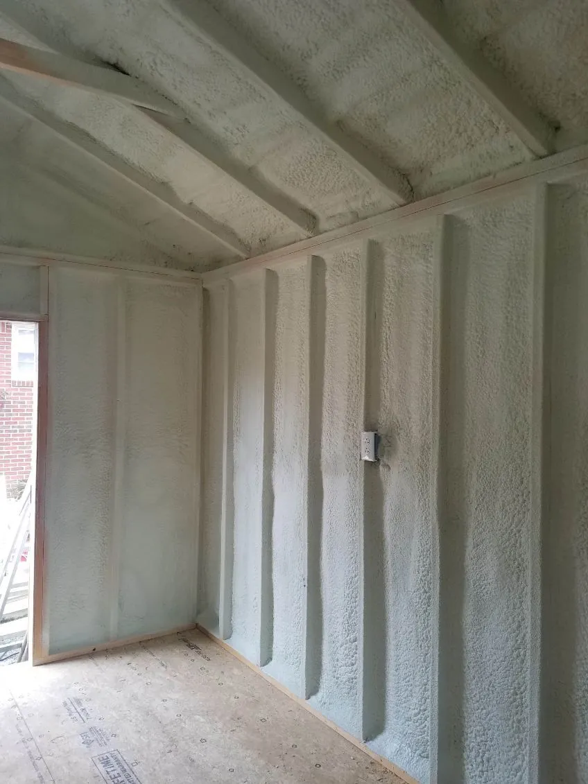 Spray foam insulation on the walls and sloped ceiling of a framed bonus room