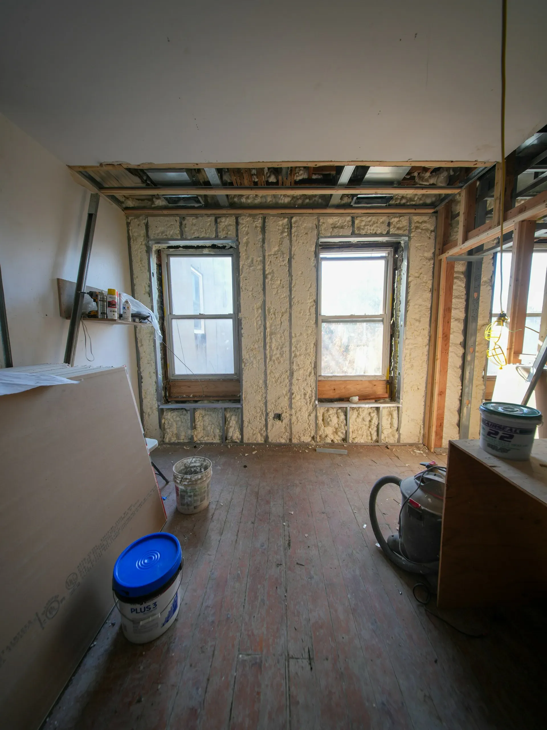 Room stripped to the studs with spray foam insulation around the window openings during a renovation